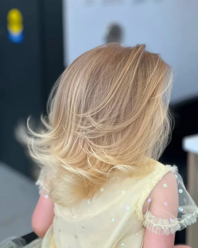 Soft blonde layers shaped through the mid-lengths